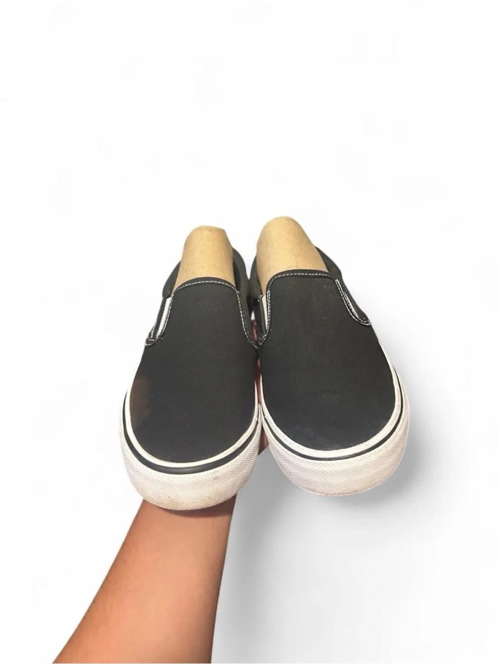 Black slip-on sneakers with white sole and white stitching
